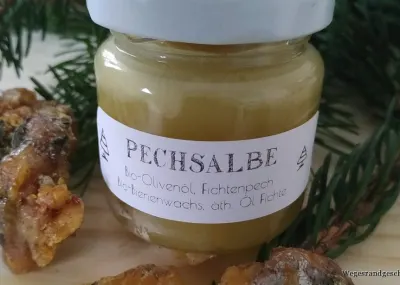 Glas Pechsalbe neben Brocken von Fichtenharz